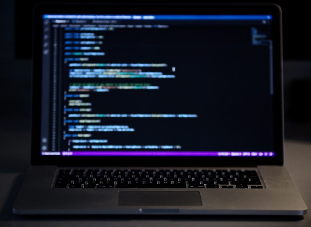 Developer coding on laptop with AI code suggestions on screen